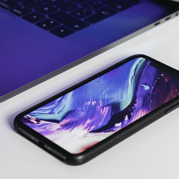 Smartphone mit lila Hintergrundbild